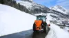 VSA zand- en zoutstrooier aan het werk op een besneeuwde weg in de bergen