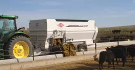 Remolque con caja de descarga BTC 172 que reparte alimento para ganado.