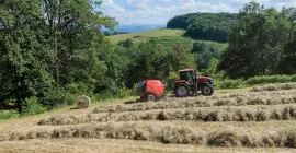 La presse à balles rondes à chambre fixe KUHN FB 3125 en train de presser des balles rondes d'ensilage.