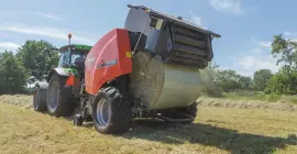 KUHN FB 3135 AUTOMATE en train d’éjecter une balle ronde liée par film.