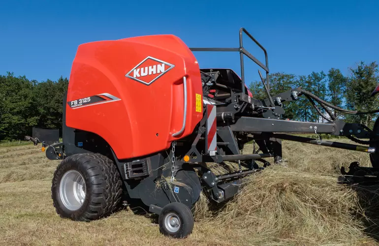 Alimentation d'une presse à balles rondes à chambre fixe KUHN FB 3125.