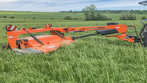 La segadora acondicionadora FC 3155 TLR trabajando en un prado.