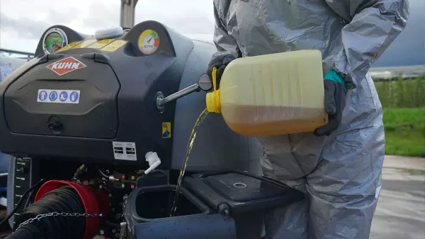 Operator emptying a drum into the GEO 2 sprayer's incorporator