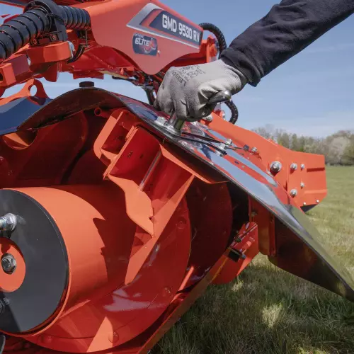 The user operates the sliding deflector adjustment handle.