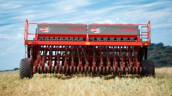 Foto en perspectiva lateral de la sembradora mecánica SDM remolcada por el tractor.