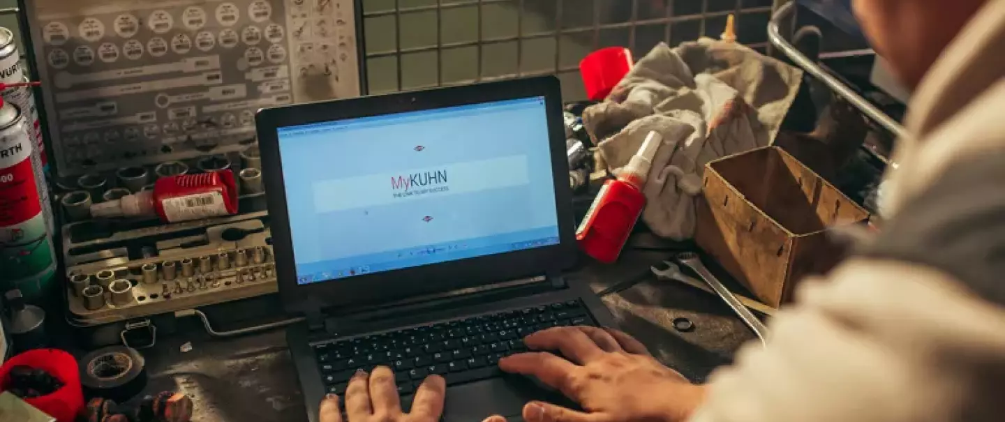 a farmer working on MyKUHN on his computer