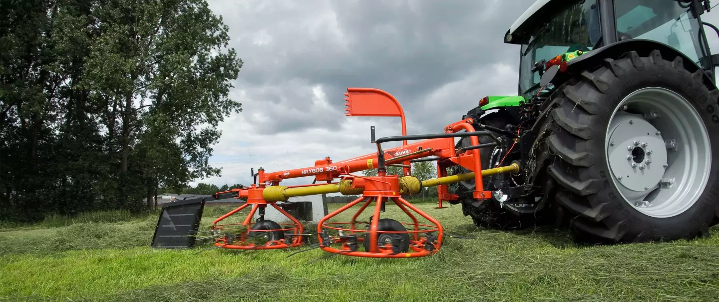 The HAYBOB 360 making a windrow under a cloudy sky.