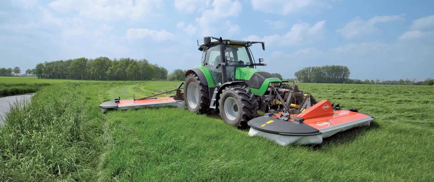Una PZ 300 F segando hierba en un prado llano en combinación con una segadora PZ montada en la parte trasera.