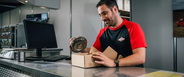 A dealer employee preparing a part ordered through MyKUHN for click and collect