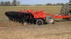 A side view of a KUHN 4830 trailed in-line ripper working the ground.