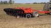 A side view of a KUHN 4830 trailed in-line ripper working the ground.