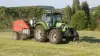 IBIO+ making bales in Austria landscape with trees on the background.