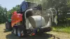 KUHN VBP 3260 baler-wrapper combination baling and wrapping bales under a blue sky.